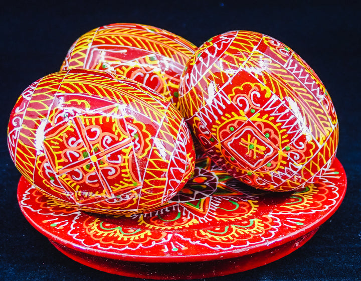 3 UKRAINIAN WOODEN PYSANKY HAND DECORATED EASTER EGGS ON A PLATE